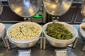 A buffet with two large bowls of food, one with cubed tofu and the other with green beans, and a sign indicating the dishes. - Jingtai Tianyiyuan Hotel (Jingtai)