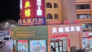 Una farmacia y un hotel con letreros iluminados.