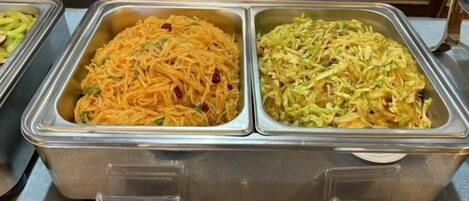 A buffet with multiple food options, including noodles and salads.