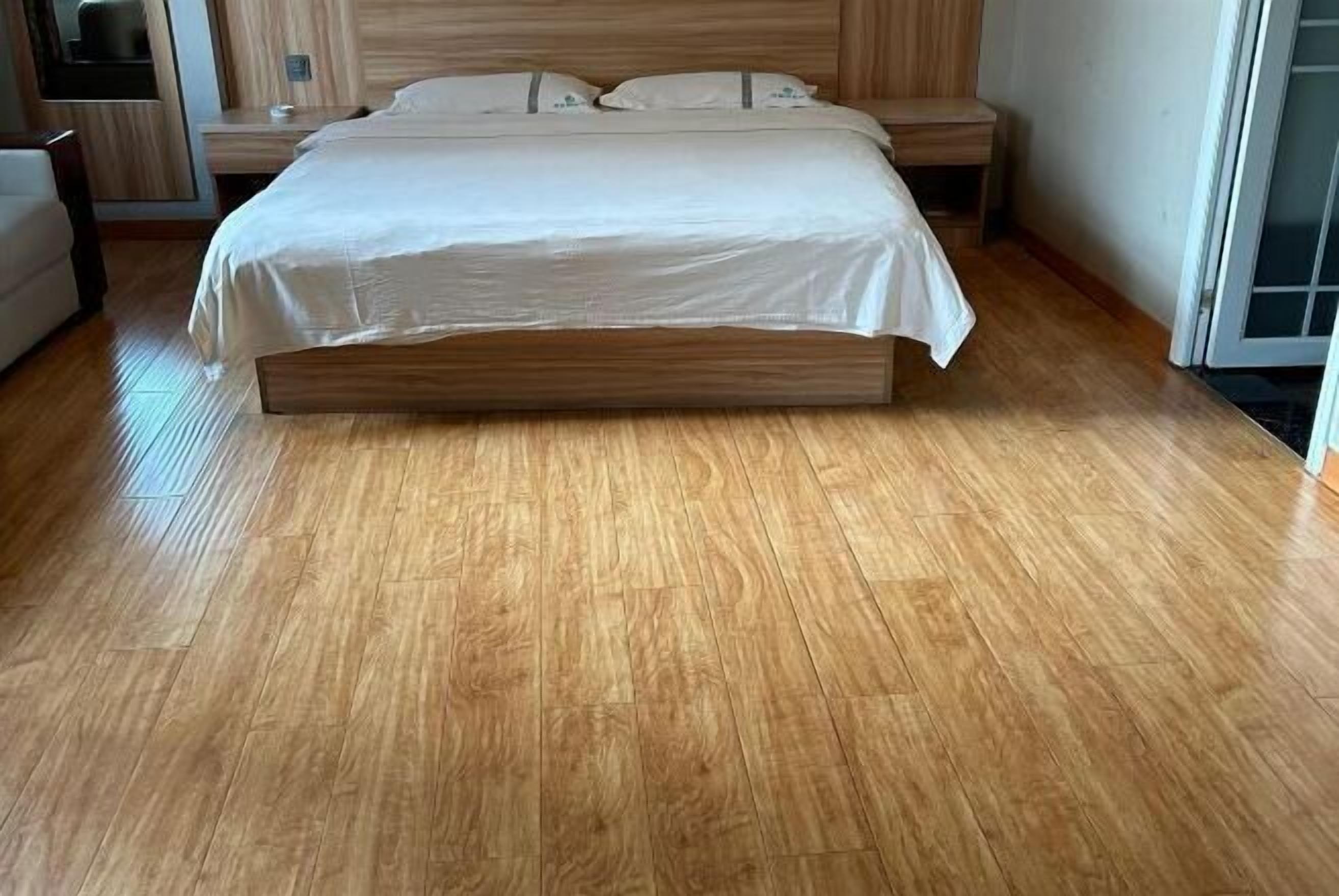 A bedroom with a wooden bed, a nightstand, a chair, and a window.
