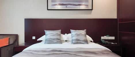Habitación de hotel con cama, mesita de noche, un cuadro en la pared y armario.