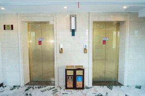 A pair of elevator doors with a control panel in the center.