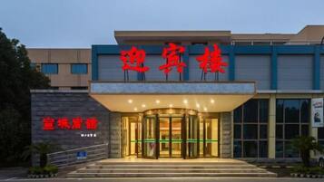 A hotel entrance with a glass door and a sign above it.
