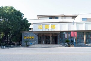 Un edificio con un letrero que dice '迎宾楼' y un letrero más pequeño debajo que dice '宾馆楼'.