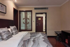A hotel room with a bed, a desk, a chair, and a door. - Xuancheng Hotel (Xuancheng)