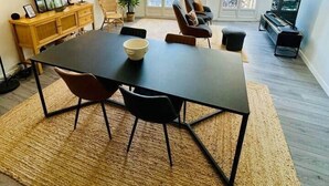 A modern living room with a dining table, chairs, a sofa, a TV, and a piano. - The best location in the city center! (Bergerac)
