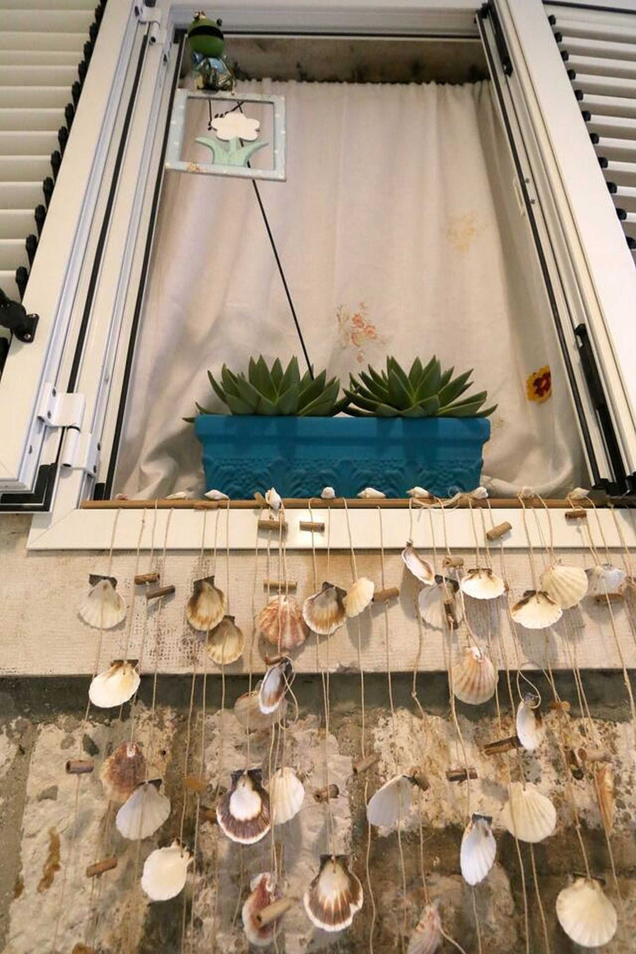 Una habitación con una cama, una ventana y una planta en el alféizar.
