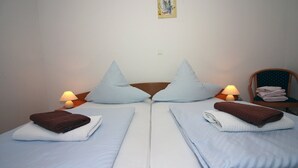 A twin room with two beds, each with a pillow and a folded towel. There are two bedside tables with lamps. - Zadar Coastal Haven - One Bedroom Apartment With Sea View (Zadar)