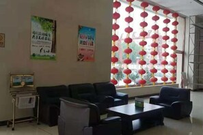 Une salle d’attente avec des canapés, une table basse et une affiche au mur.