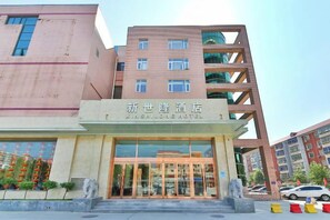 Un hôtel doté d’une façade moderne, d’une grande entrée en verre et d’une enseigne indiquant qu’il s’agit de l’hôtel Xishuangbanna.