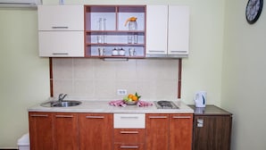 A compact kitchen with a sink, stove, and cabinets. - Charming Seaside Escape in Kotor - One Bedroom Apartment with Garden 3 (Donji Stoliv)