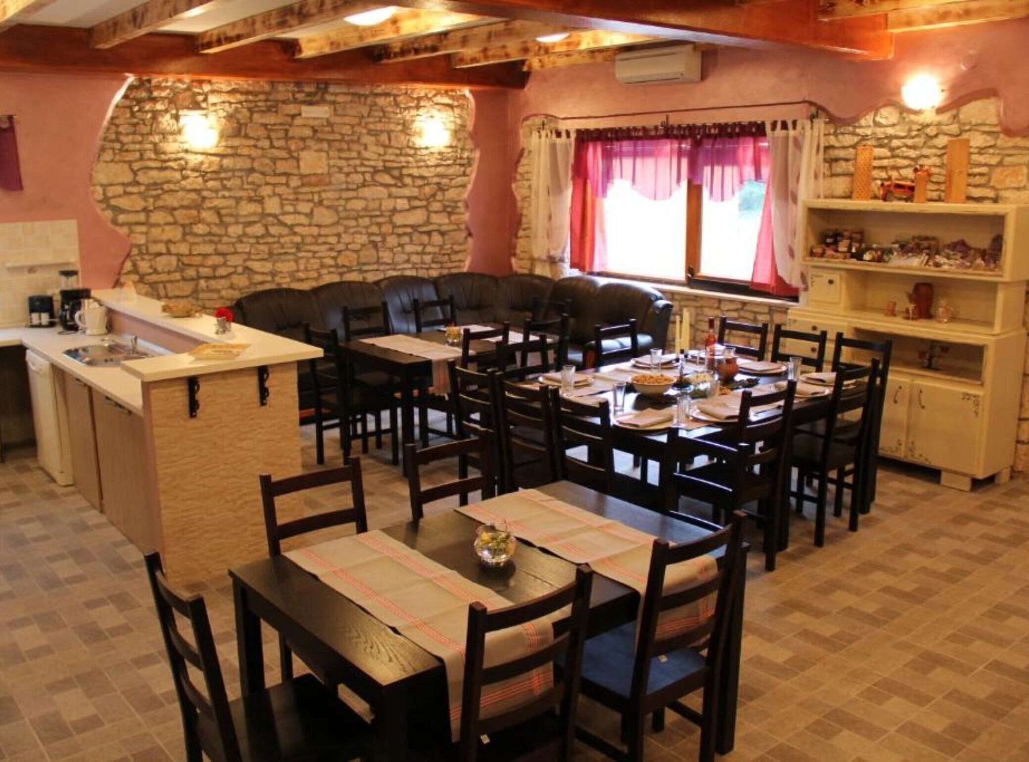 A cozy dining area with a stone wall, a built-in bar, and a seating arrangement for guests.