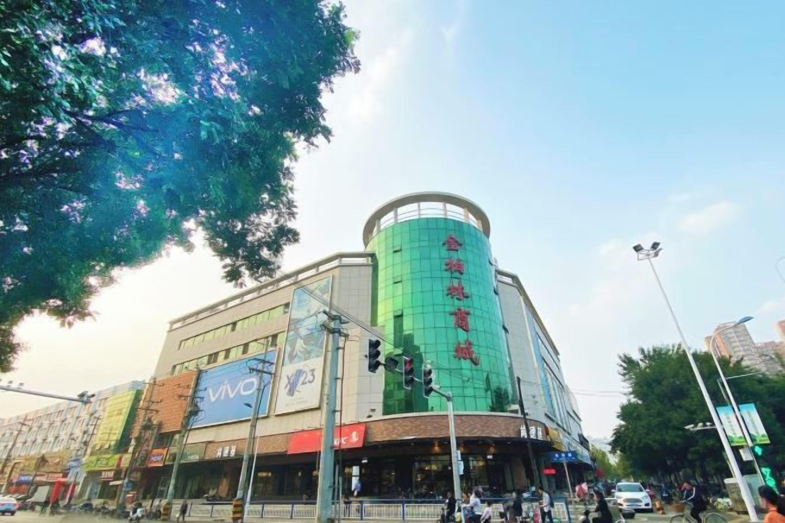 A multi-story building with a prominent cylindrical section and signage indicating a commercial area.