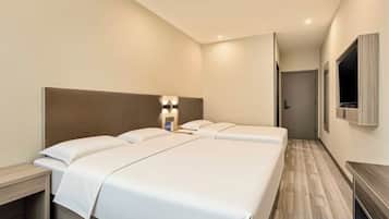 Een hotelkamer met een groot bed, nachtkastjes, een televisie en een spiegel.