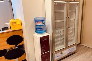 Une chambre d’hôtel équipée d’un mini-bar, d’un distributeur d’eau et d’un réfrigérateur.