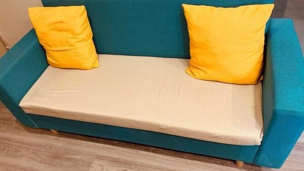 A teal sofa with two yellow cushions and a beige throw blanket. - Yiju Hotel (Shijiazhuang Zhonghua North Street Branch) (Shijiazhuang)