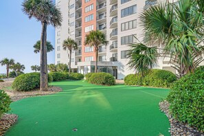 Ein Golfplatz mit einem Gebäude im Hintergrund.