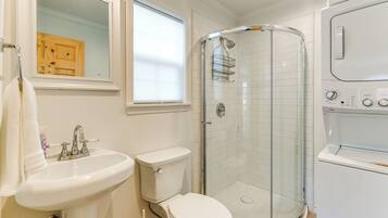 Une salle de bain moderne avec une douche à parois de verre, un lavabo blanc et des toilettes.