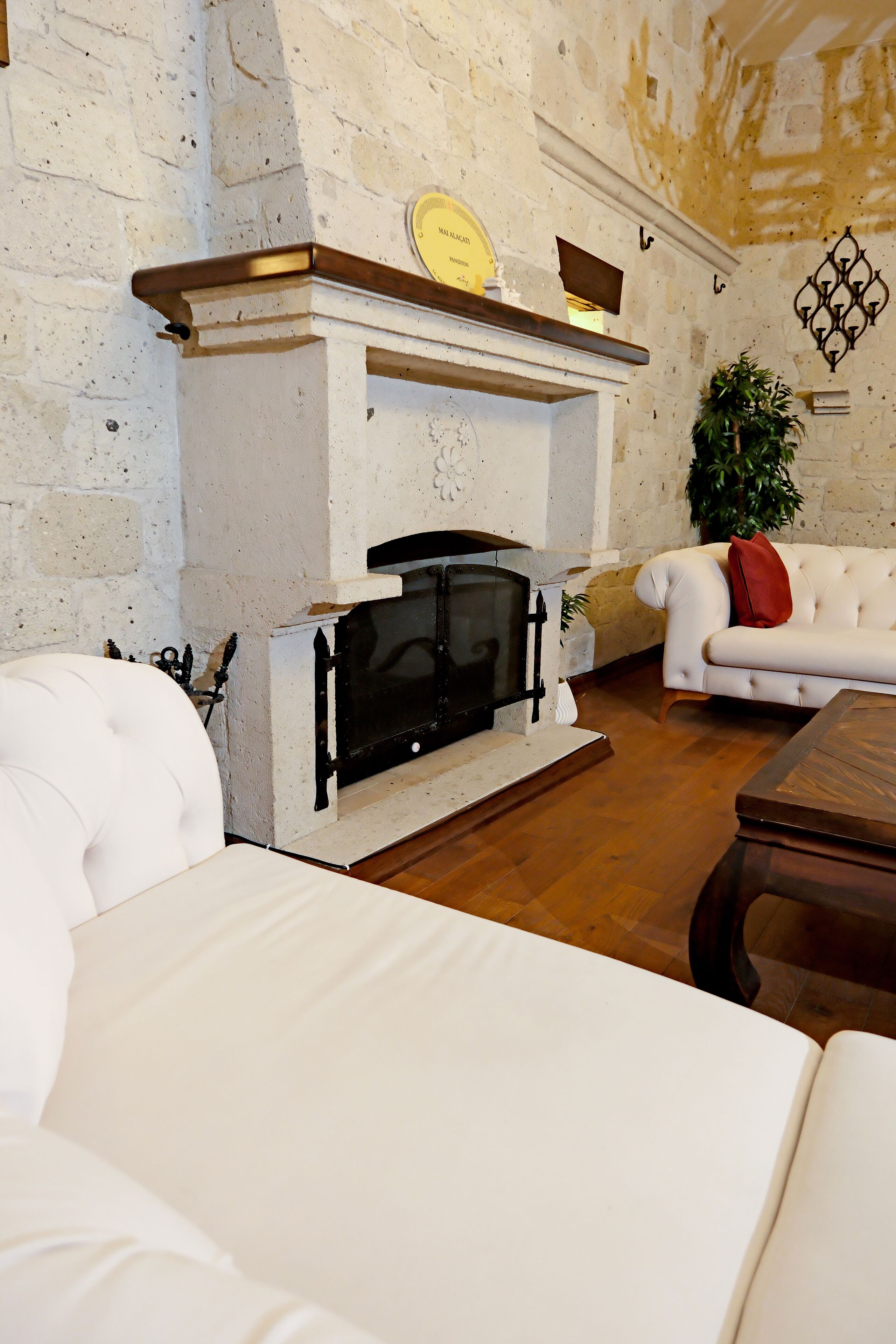 A living room with a fireplace, white leather sofas, and a wooden coffee table.