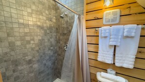 Een badkamer met douche, toilet en handdoekhouder.