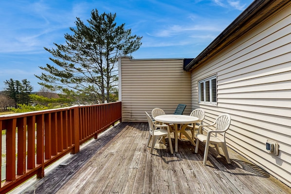 Enjoy outdoor dining and socializing on this deck with a round table and four chairs.