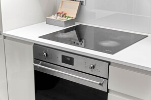 Une cuisine moderne dotée d’une plaque de cuisson intégrée, de deux fours et d’un four à micro-ondes.