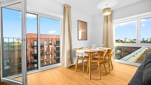 Un apartamento moderno con comedor, ventanas amplias y vistas a la ciudad.