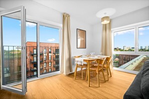 Eine moderne Wohnung mit Essbereich, großen Fenstern und Blick auf die Stadt.