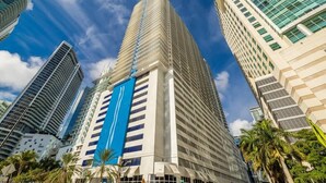 A tall, modern building with a prominent blue stripe and multiple floors.