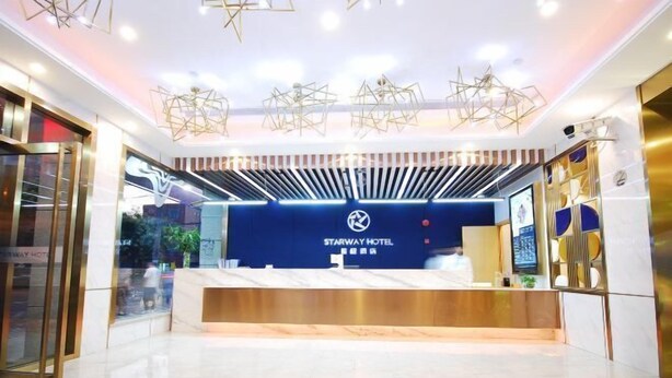 A modern hotel reception area with a blue counter, Starway Hotel logo, and geometric ceiling lights. - Starway Hotel Shanghai Wujiaochang Changhai H (Shanghai)