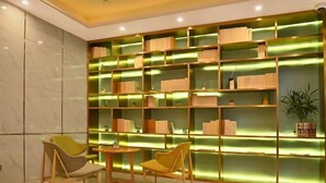 A modern library with bookshelves and two chairs. - Starway Hotel Shanghai Wujiaochang Changhai H (Shanghai)