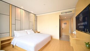 A modern hotel room with a large bed, wooden headboard, bedside tables, a desk, and a reception area. - Starway Hotel Shanghai Wujiaochang Changhai H (Shanghai)