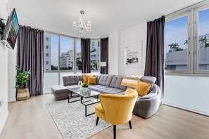 Ein modernes Wohnzimmer mit einem grauen Sofa, einem gelben Sessel und einem Glastisch.