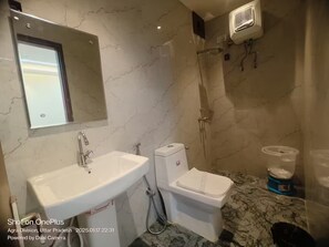 Een douche, handdoeken, zeep, toiletpapier