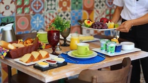A breakfast table with bread, fruit, juice, and condiments. - Pousada Estação Bananeiras (Bananeiras)