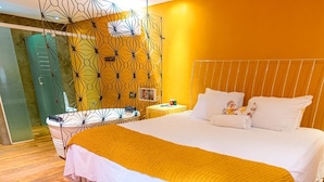 A hotel room with a large bed, a yellow blanket, and a patterned floor. - Pousada Estação Bananeiras (Bananeiras)
