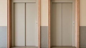Two closed doors with wooden frames and a light-colored wall. - Perla do Oceano – Funchal Sea View with XL Terrace (Funchal)