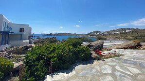 A coastal view with white buildings, a stone pathway, and a clear blue sky.