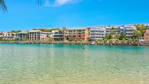 A coastal hotel with multiple balconies, a marina, and clear turquoise water. - Creekfront Kingscliff Waters 5 (Kingscliff)