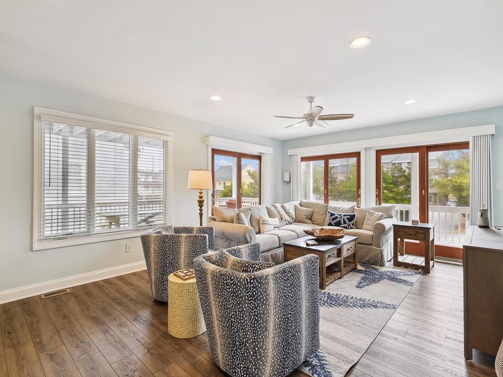 A spacious living room with a sofa set, a coffee table, and a ceiling fan.