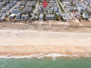 Vista aérea de una zona residencial costera con casas, una playa y un lugar marcado.