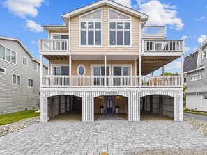 A two-story house with a balcony, a front entrance, and a driveway.