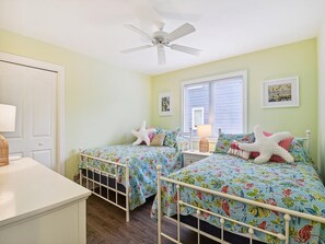 A bedroom with two beds, a ceiling fan, a window with blinds, and a door. - Coastal Escape w/ Views | Steps from Bethany Beach (Bethany Beach)