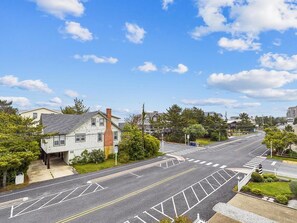 A residential street with houses, a clear sky, and a crosswalk. - Coastal Escape w/ Views | Steps from Bethany Beach (Bethany Beach)
