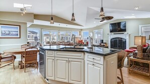 A spacious kitchen with a large island, white cabinetry, and pendant lighting. - Steps to Bethany Beach | Luxury Ocean Block Home (Bethany Beach)