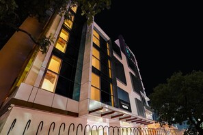 Un hotel moderno con un llamativo letrero 'TOWNHOUSE', ventanas amplias y una fachada bien iluminada.