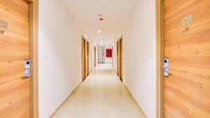 A long, narrow hallway with wooden doors on both sides, numbered 104 and 108, leading to rooms.