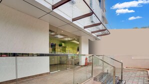 A modern building with a glass facade, a staircase with glass railings, and a fire extinguisher.