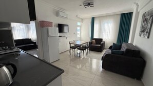 A modern apartment with a kitchen, dining area, and living room. - Elitaş Apart Otel (Fethiye)