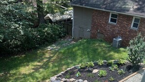 A rooftop garden with a small table and chairs, surrounded by a gravel path and various plants. - The Loft (Kennesaw)